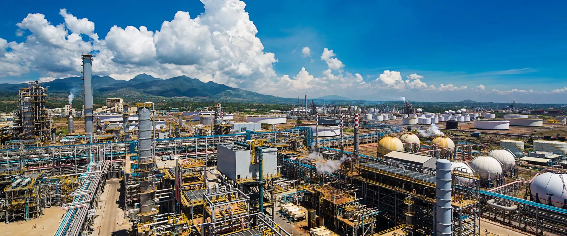 Vista aérea de uma planta industrial com tubulações, tanques e estruturas metálicas