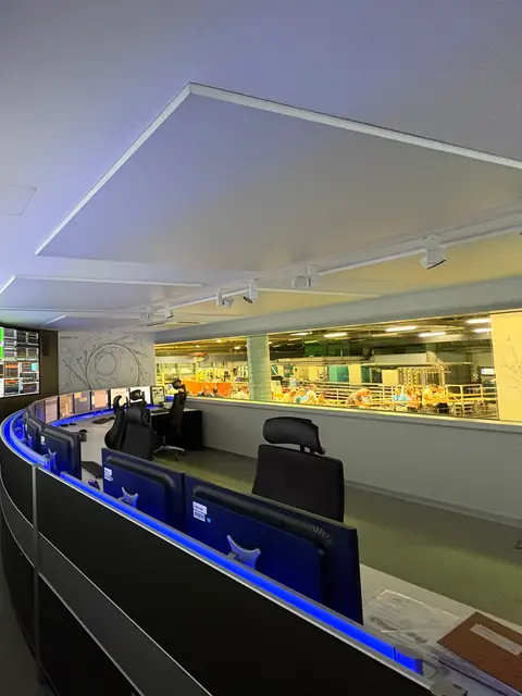 Sala de controle com mesa de operação e telas de supervisão
